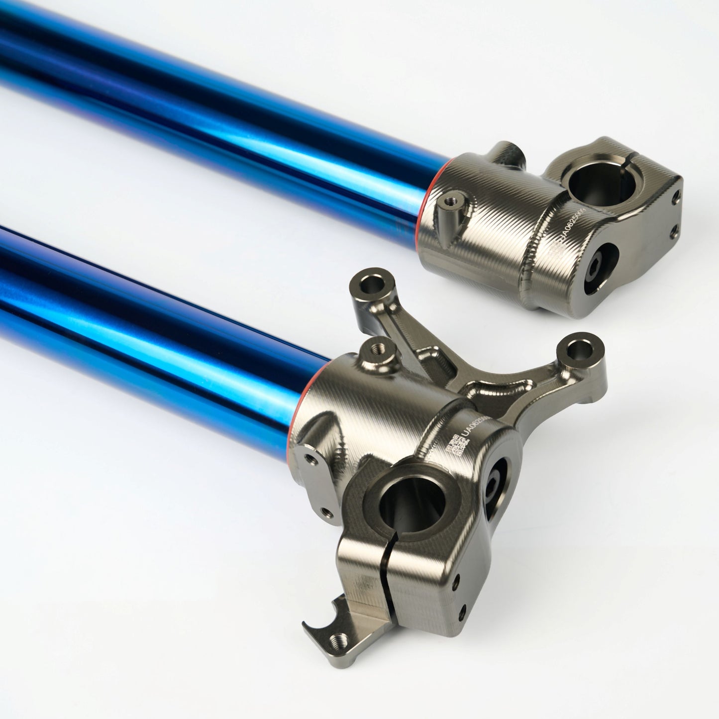 Two metal suspension links with blue anodized finish on a white background