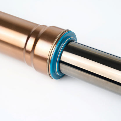 Close-up of a traxion fork and black stanchions with a blue seals on a white background